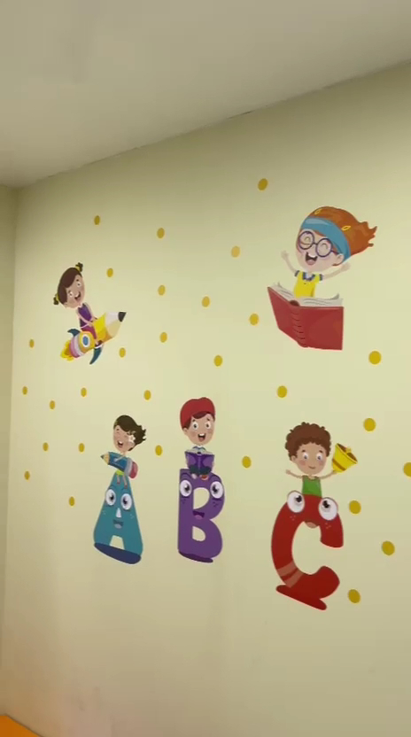 Parede decorada com personagens e letras na Clínica Projetar ABC